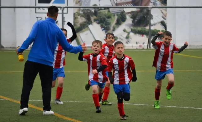 Trener piłki nożnej i młodzi zawodnicy na boisku
